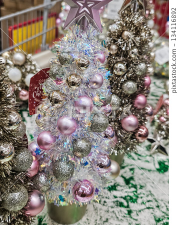 Close-up of a sparkling Christmas tree made of small silver and pink ball ornaments. Festive decoration suitable for holiday displays, seasonal decor, and Christmas-themed projects. Close-up of a sparkling Christmas tree made of small silver and pink ball ornaments. Festive decoration suitable for holiday displays, seasonal decor, and Christmas-themed projects. 134116892