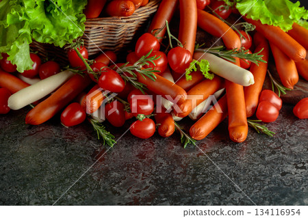 Various thin smoked sausages with salad, tomatoes, and rosemary. Various thin smoked sausages with salad, tomatoes, and rosemary. 134116954