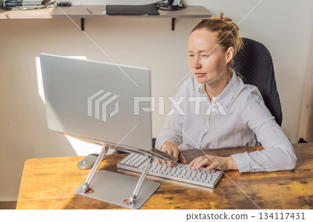 Woman working in her home office, focused on her laptop and daily tasks, creating a calm and productive workspace. Remote work, professional lifestyle and modern productivity concept representing Woman working in her home office, focused on her laptop and daily tasks, creating a calm and productive workspace. Remote work, professional lifestyle and modern productivity concept representing 134117431