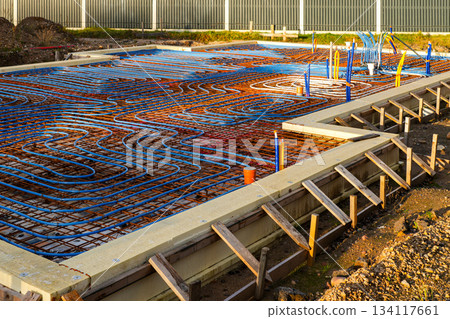 Underfloor heating pipes installed on reinforced foundation before concrete pouring Underfloor heating pipes installed on reinforced foundation before concrete pouring 134117661
