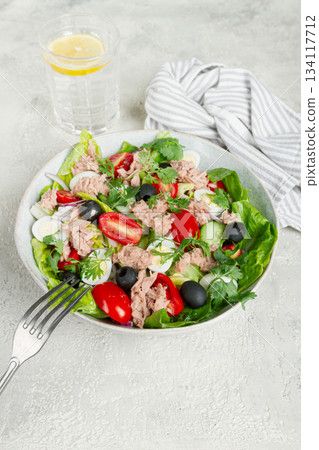 salad with canned tuna, vegetable salad with quail eggs, lettuce and romaine leaves, red onion, cherry tomatoes, olives, keto food, healthy eating, 134117712
