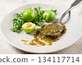 a spoon with tkemali sauce, on a plate, with cherry plum and mint, top view, no people, 134117714