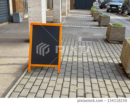 Blank sidewalk chalkboard stand. Street advertising, pedestrian zone, city environment and waiting commercial message copy space Blank sidewalk chalkboard stand. Street advertising, pedestrian zone, city environment and waiting commercial message copy space 134118239