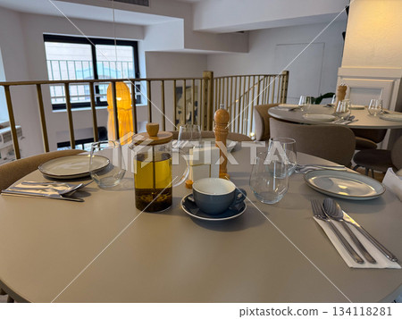 Served table with tea pot and place settings. Dining mood, hospitality, gathering, warm social interaction 134118281