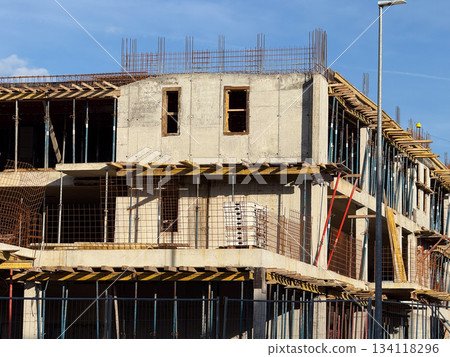 Close view of unfinished concrete building walls and metal reinforcement grid. Infrastructure, construction progress, raw architecture and urban growth. Close view of unfinished concrete building walls and metal reinforcement grid. Infrastructure, construction progress, raw architecture and urban growth. 134118296
