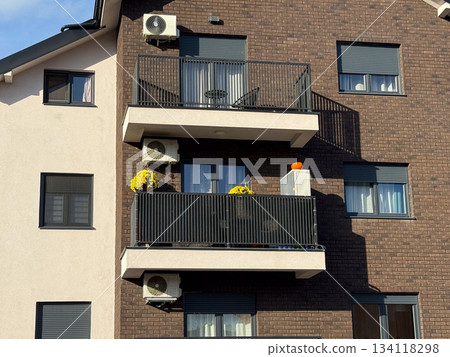 Modern apartment balcony with yellow chrysanthemums and pumpkin decor. Seasonal home aesthetics, autumn decoration, architecture and urban homelife style. 134118298