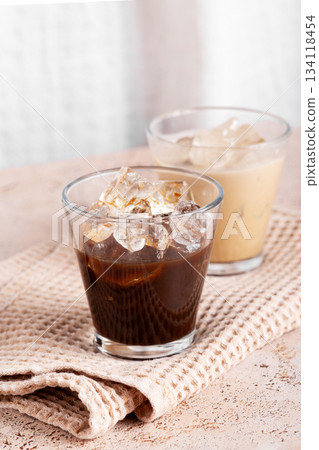 Iced latte and dark coffee side by side in minimalist composition Iced latte and dark coffee side by side in minimalist composition 134118454