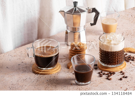 Freshly brewed espresso, iced coffee and moka pot in cozy kitchen setup Freshly brewed espresso, iced coffee and moka pot in cozy kitchen setup 134118484