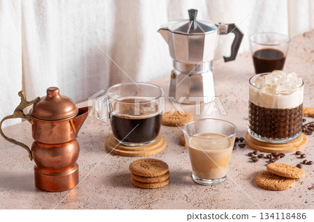Coffee assortment with espresso cups, iced drink and moka pot on beige table 134118486