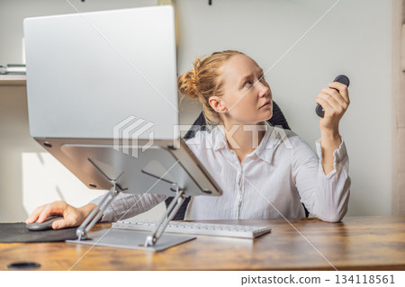 Woman working in her home office, focused on her laptop and daily tasks, creating a calm and productive workspace. Remote work, professional lifestyle and modern productivity concept representing 134118561