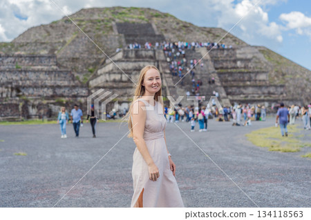 Female tourist standing in front of Teotihuacan pyramids in Mexico, enjoying sightseeing, adventure, and cultural heritage. Travel, tourism, and exploration concept 134118563