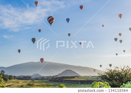 Colorful hot air balloons floating over Teotihuacan in Mexico, creating a breathtaking view of the ancient pyramids. Tourism, adventure, and cultural heritage concept Colorful hot air balloons floating over Teotihuacan in Mexico, creating a breathtaking view of the ancient pyramids. Tourism, adventure, and cultural heritage concept 134118564