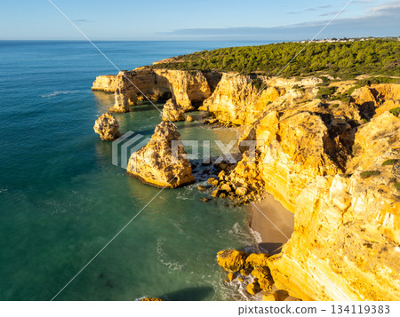 Marinha Beach, Cliffs and Atlantic Ocean on Sunny Day. Aerial View. Portugal Marinha Beach, Cliffs and Atlantic Ocean on Sunny Day. Aerial View. Portugal 134119383