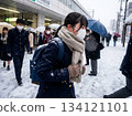 A female high school student wearing a mask walks to school in front of a station in heavy snow [Winter commute, exam day, bad weather] 134121101