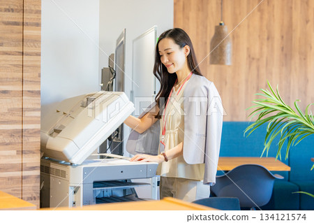 Female employee making copies Female employee making copies 134121574