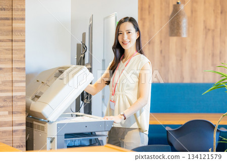 Female employee making copies Female employee making copies 134121579