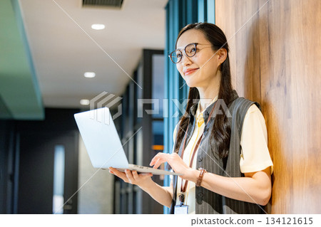 Business woman standing in the office corridor 134121615
