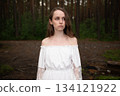 Serene Solitude: Woman in White Off-Shoulder Dress amidst Forest Tall Trees 134121922