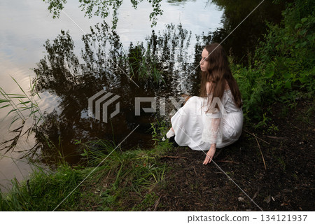 Contemplation by the Water: Woman in White Dress Gazing at the Lake Contemplation by the Water: Woman in White Dress Gazing at the Lake 134121937