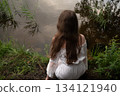 Contemplation by the Water: Woman in White Dress Gazing at the Lake 134121940