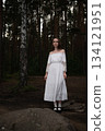 Woman in Vintage White Off-Shoulder Dress amidst Pine Forest 134121951