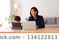 A mother working from home and her child learning online in a bright room. 134122813