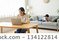 A mother working from home and her child doing homework. Parents and children spending time together smiling in a bright living room. 134122814