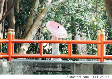 一位女孩在神社裡撐著一把日式傘，向七五三祈禱。 134124054