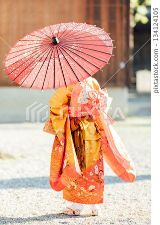 一位女孩在神社裡撐著一把日式傘，向七五三祈禱。 134124105