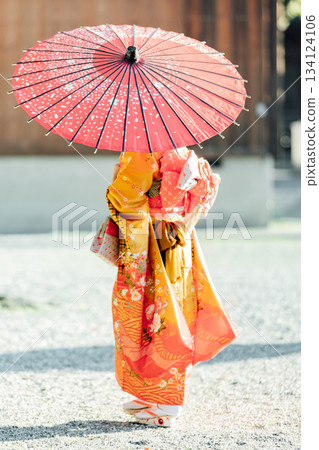 一位女孩在神社裡撐著一把日式傘,向七五三祈禱。 一位女孩在神社裡撐著一把日式傘,向七五三祈禱。 134124106