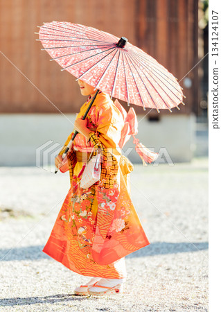 一位女孩在神社裡撐著一把日式傘,向七五三祈禱。 一位女孩在神社裡撐著一把日式傘,向七五三祈禱。 134124107