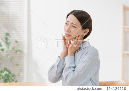 Woman touching her chin and neck 134124218