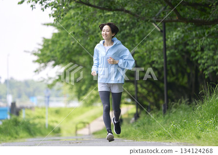 一位 40 多歲的女性在戶外跑步 134124268