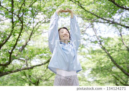 一名 40 多歲的女性在戶外進行熱身運動 134124271