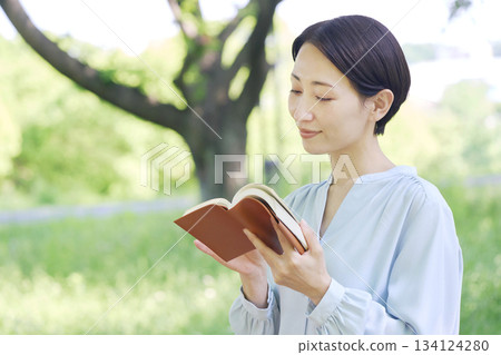 Woman reading outdoors Woman reading outdoors 134124280