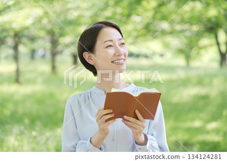 Woman reading outdoors Woman reading outdoors 134124281