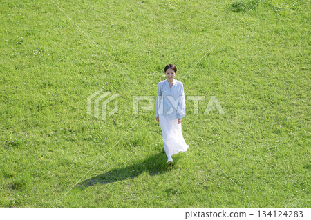 Aerial view of a woman walking in the fields Aerial view of a woman walking in the fields 134124283