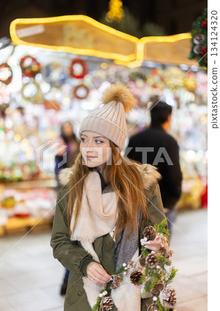 Young woman walking in the evening Christmas market 134124320