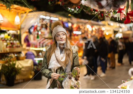 Young woman walking in the evening Christmas market Young woman walking in the evening Christmas market 134124350