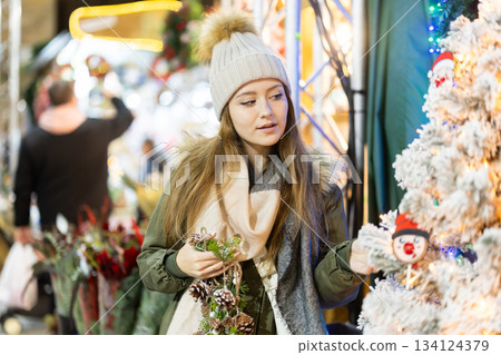 Young woman walking along a decorated street for the new year Young woman walking along a decorated street for the new year 134124379