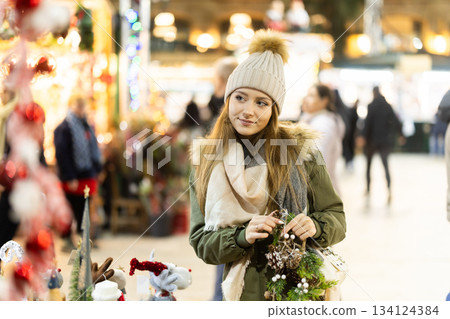 Young woman walking along a decorated street for the new year Young woman walking along a decorated street for the new year 134124384