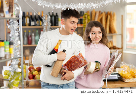 Couple shopping gourmet snacks and wine for New Year celebration 134124471