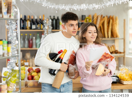 Couple man and woman choosing food from shopping list 134124539