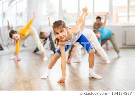 Happy smiling preteen dancers practicing dance routine with female choreographer in studio Happy smiling preteen dancers practicing dance routine with female choreographer in studio 134124557