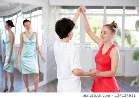 Motivated adolescent ballroom dancers practicing dance moves in studio Motivated adolescent ballroom dancers practicing dance moves in studio 134124611