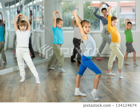 Group of happy preteen children with female teacher practicing hip hop in dance studio 134124674