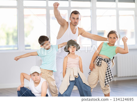 Group of preteen kids in hip hop dance class posing with instructor 134124695