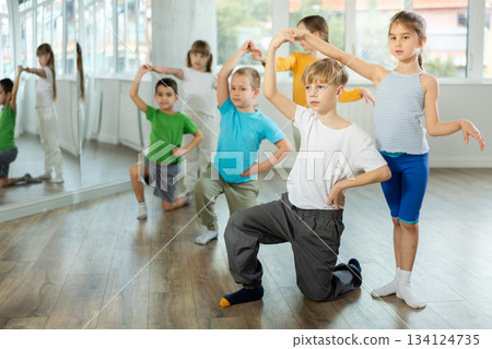 Happy preteen children practicing ballroom dances in pairs in training hall Happy preteen children practicing ballroom dances in pairs in training hall 134124735