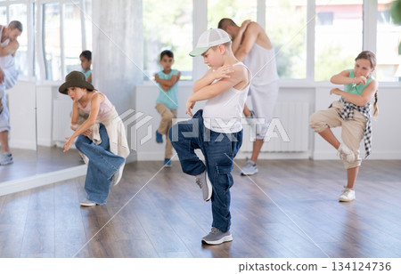 Dance group of children in casual clothes are training together to dance hip-hop and breakdancing in dance center Dance group of children in casual clothes are training together to dance hip-hop and breakdancing in dance center 134124736