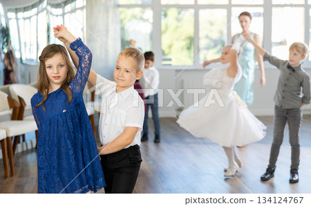 Tween girls ad boys dancing slow partner dance during festive event Tween girls ad boys dancing slow partner dance during festive event 134124767